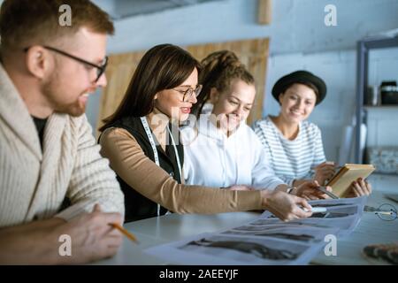 Giovani designer creativi a discutere di moda schizzi durante il lavoro in studio Foto Stock