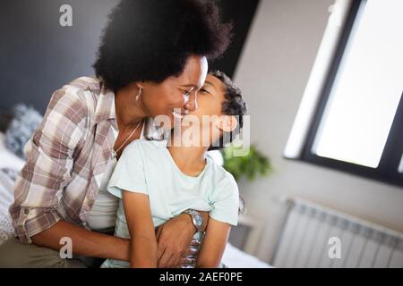 Felice madre giocare, divertirsi, abbracciando con suo figlio a casa Foto Stock