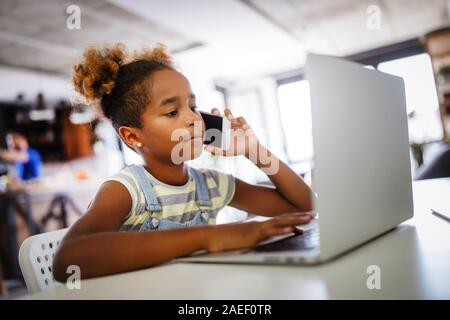 Gioco, studio, concetto di divertimento. Dei bambini felici di trascorrere del tempo con i notebook e tecnologia moderna. Foto Stock