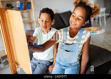 Carino Bambini ragazza ragazzo e pittura insieme. Educazione, arte, il divertimento e la creatività del concetto. Foto Stock