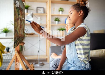 Carino Bambini ragazza ragazzo e pittura insieme. Educazione, arte, il divertimento e la creatività del concetto. Foto Stock