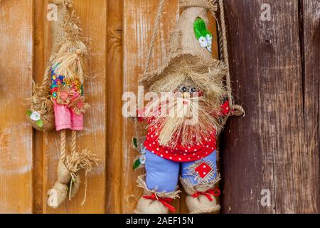 Tre bambole di tessili in bianco e rosso T-shirt con piccole scatole di legno. Foto Stock