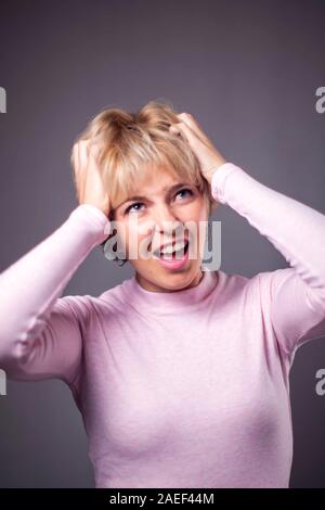 Donna con corti capelli biondi sensazione arrabbiato. Le persone e le emozioni concetto Foto Stock