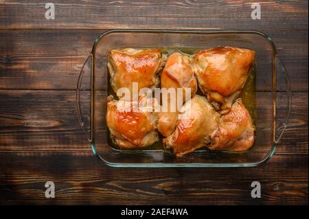 In casa cotto al forno cosce di pollo con salsa di soia e spezie in un vassoio di vetro Spazio di copia Foto Stock