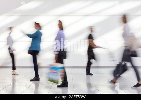 Molti anonimo sfocato persone andare a fare shopping nel centro commerciale Foto Stock