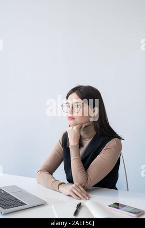 Giovane serio economista femmina concentrandosi su analisi della situazione finanziaria Foto Stock