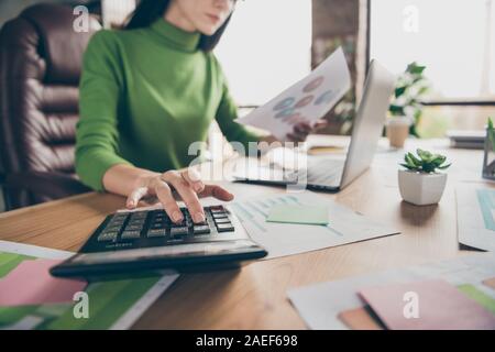 Ritagliato closeup foto di busy business notebook lady tabella tenere statistiche della carta numeri di calcolo di somme di denaro reddito sedia sit usura turtleneck verde Foto Stock