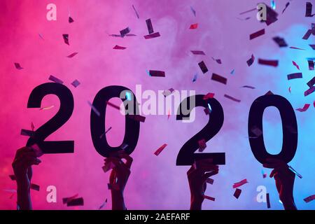 Immagine di sfondo di mani 2020 durante la festa di Natale in discoteca con scintillante di coriandoli, spazio di copia Foto Stock
