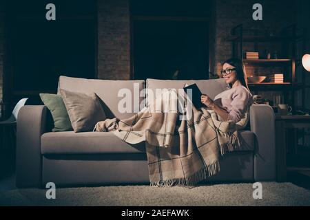 Foto del profilo della casalinga lady leggere appassionante romanzo storico interessato prenota worm seduta lettino coperta calda coperta a scacchi abiti casual occhiali Foto Stock