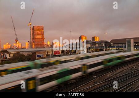 A sud del treno si avvicina Clapham Junction al sorgere del sole Foto Stock