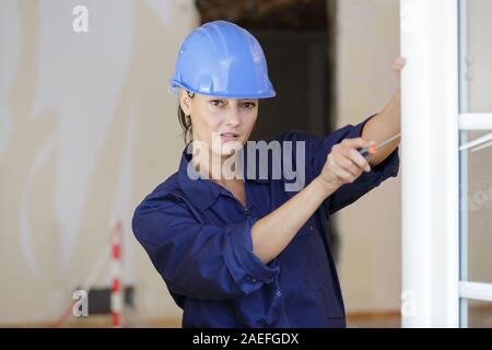 Generatore femmina cacciavite stringe la fissazione di una finestra Foto Stock