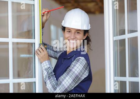 Architetto femmina prendendo misure di una finestra Foto Stock