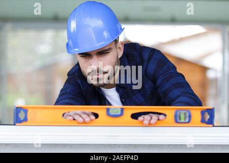 L uomo è in possesso di un livello di edificio Foto Stock