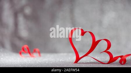 San Valentino scheda Giorni. Nastro rosso a forma di cuore sulla tavola di legno Foto Stock