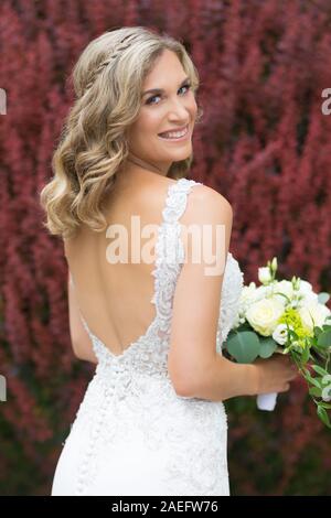 Nozze. Bella Sposa in abito bianco azienda Bouquet nozze. Foto Stock