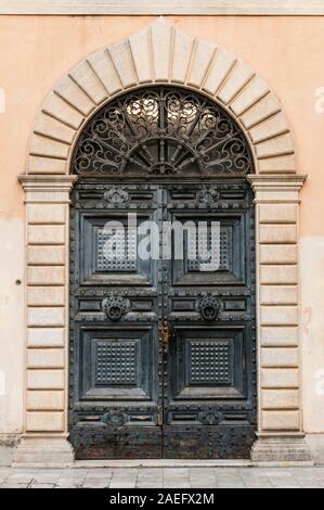 Nero il legno vecchio portale con ferro e decorazioni in marmo all'entrata principale dell'Arte Accademia Carrara, Italia Foto Stock