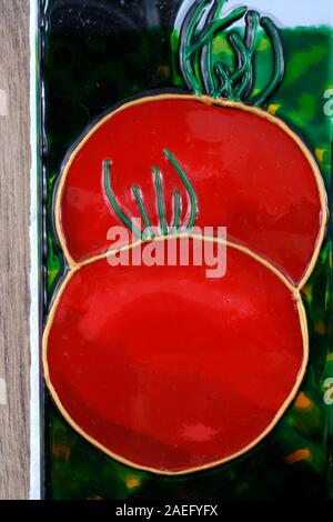 Vetro dipinte pomodori rossi su uno specchio. Foto Stock