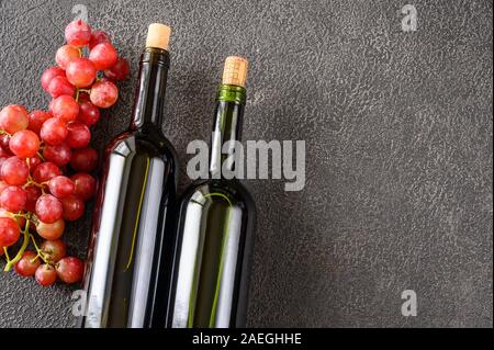 Bottiglie di vino rosso con grappolo di uva laici piatta Foto Stock