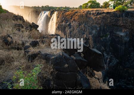 Victoria Falls, che prende il nome da David Livingstone nel 1855 dopo la regina Victoria, la cascata è formata dal fiume Zambesi che cade in un 100 metro profondo ch Foto Stock