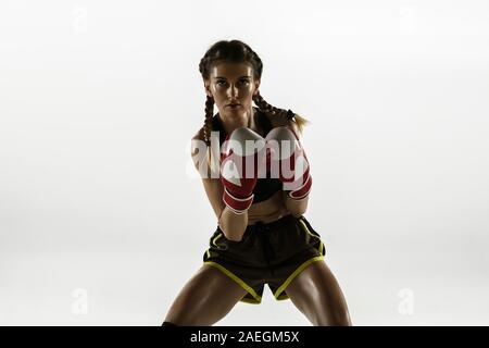 Montare donna caucasici nella boxe abbigliamento sportswear isolato su bianco di sfondo per studio. Il debuttante femmina boxer caucasica la formazione e la pratica di movimento e di azione. Sport e stile di vita sano, concetto di movimento. Foto Stock