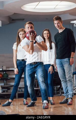 Giovani amici allegro divertirsi in bowling club presso i loro fine settimana Foto Stock