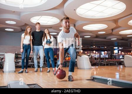 Andando a vincere. Giovani amici allegro divertirsi in bowling club presso i loro fine settimana Foto Stock