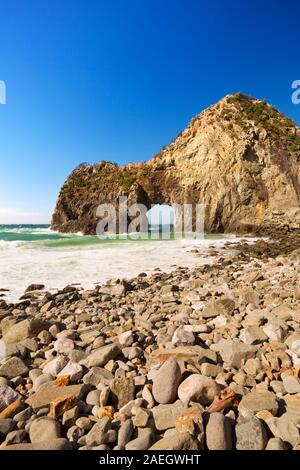 L'arco naturale Senganmon (千貫門) sulla costa rocciosa della Penisola di Izu in Giappone su una bella giornata splendente. Foto Stock