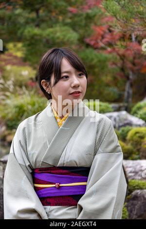 Modello femminile in posa al tempio buddista Zen Tenryū-ji, Kyoto, Giappone Foto Stock