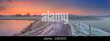 Tipico paesaggio olandese su un gelido mattino all'alba. Questa è una parte della circolare West-Frisian Dyke, una diga sistema che protegge un grande Foto Stock