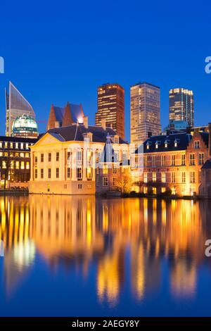 Il Parlamento olandese edifici al Binnenhof da tutto il laghetto Hofvijver all'Aia, nei Paesi Bassi la notte. Foto Stock