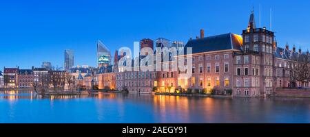 Il Parlamento olandese edifici al Binnenhof da tutto il laghetto Hofvijver all'Aia, nei Paesi Bassi la notte. Foto Stock