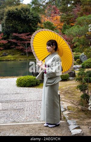 Modello femminile in posa al tempio buddista Zen Tenryū-ji, Kyoto, Giappone Foto Stock