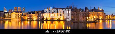 Il Parlamento olandese edifici al Binnenhof da tutto il laghetto Hofvijver all'Aia, nei Paesi Bassi la notte. Foto Stock