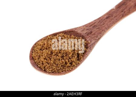 Cucchiaio di legno pieno di luce dolce zucchero bruno isolato su uno sfondo bianco Foto Stock