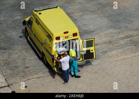 Aruba-11/4/19: il personale di ambulanza e la nave di crociera equipaggio su un dock in Aruba prendendo un passeggero disattivato la nave per il loro trasporto in ospedale per un me Foto Stock