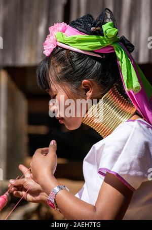 Ritratto di una giovane donna dalla tribù Kayan indossando il vestito tradizionale (e un moderno guarda) e collana in ottone. Pan Pet, Loikaw, Myanmar. Foto Stock