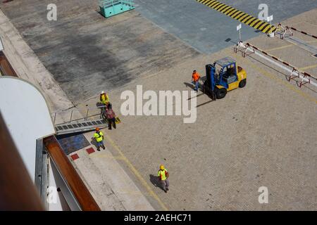 Aruba-11/4/19: porta i lavoratori portuali e la nave di crociera equipaggio lavorando duramente l'impostazione di una rampa per il trasporto di passeggeri su off la nave. Foto Stock