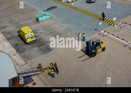 Aruba-11/4/19: porta i lavoratori portuali e la nave di crociera equipaggio lavorando duramente l'impostazione di una rampa per il trasporto di passeggeri su off la nave. Foto Stock