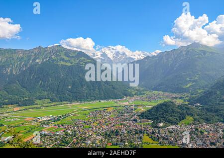 Splendida vista di Interlaken e montagne adiacenti fotografata dalla cima di Harder Kulm in Svizzera. Alpi svizzere paesaggio. Città nella valle alpina circondata da montagne. Giornata di sole. Foto Stock