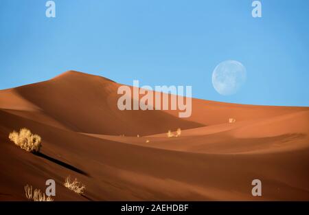 Luna piena sorgere nella lut deserto che è il luogo più caldo della terra Foto Stock