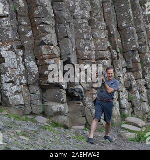 Fotografo di fronte di roccia basaltica, giganti Causeway, County Antrim, Irlanda del Nord, Regno Unito Foto Stock