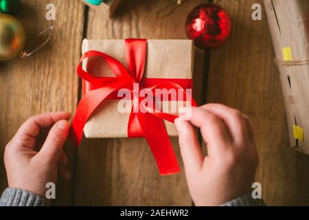 Donna di incarto regali di natale su sfondo di legno Foto Stock