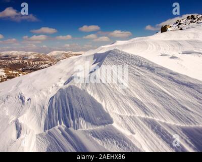 Neve sagomata e ripulita da un forte vento quando cadde, sopra Wrynose Pass nel distretto del lago, Cumbria, Regno Unito. Foto Stock