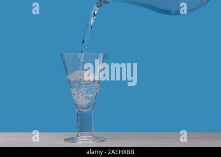 Bicchiere di acqua essendo riempito con acqua fresca Foto Stock