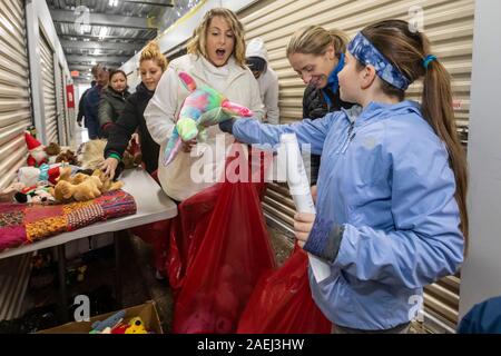 Madison Heights, Michigan - Volontari da ebrei, cristiani e musulmani di organizzazioni e di ordinamento pack donato regali di Natale per i bambini svantaggiati Foto Stock