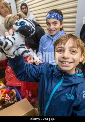 Madison Heights, Michigan - Volontari da ebrei, cristiani e musulmani di organizzazioni e di ordinamento pack donato regali di Natale per i bambini svantaggiati Foto Stock