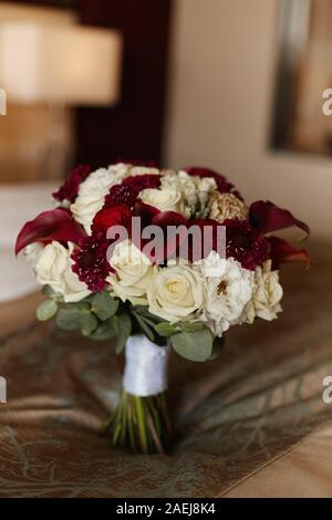 Lussureggiante bridal bouquet di fiori esotici, closeup, sfondo sfocato. Concetto di cartolina di matrimonio. Lusso bouquet nuziale con calla gigli e peonie rose Foto Stock