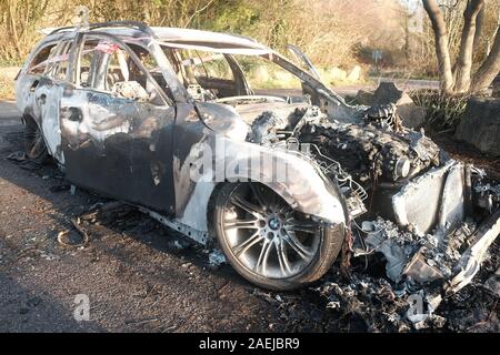 Dicembre 2019 - bruciata rubato BMW station wagon che era stata volutamente impostata sul fuoco per distruggere le prove. Foto Stock