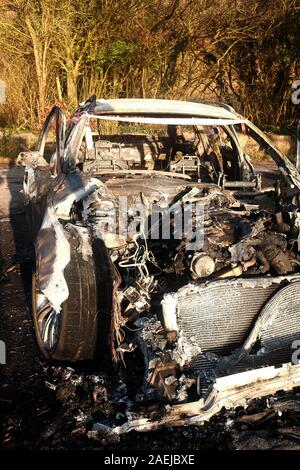 Dicembre 2019 - bruciata rubato BMW station wagon che era stata volutamente impostata sul fuoco per distruggere le prove. Foto Stock