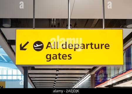 Un grande cartello giallo pende dal soffitto a Heathrow Airport Terminal 5 rivolto verso i cancelli di partenza. Foto Stock